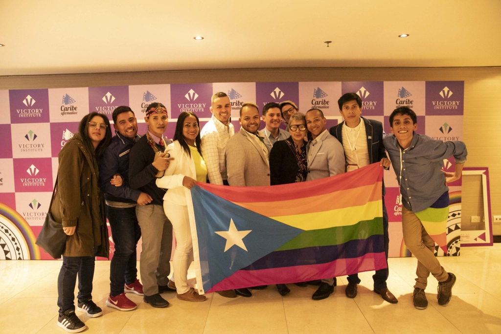 Conference attendees posing with a Puerto Rican rainbow flag, Colombia