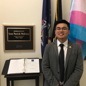A Victory Congressional Intern poses in front of the office sign for Representative Sean Patrick Maloney;.