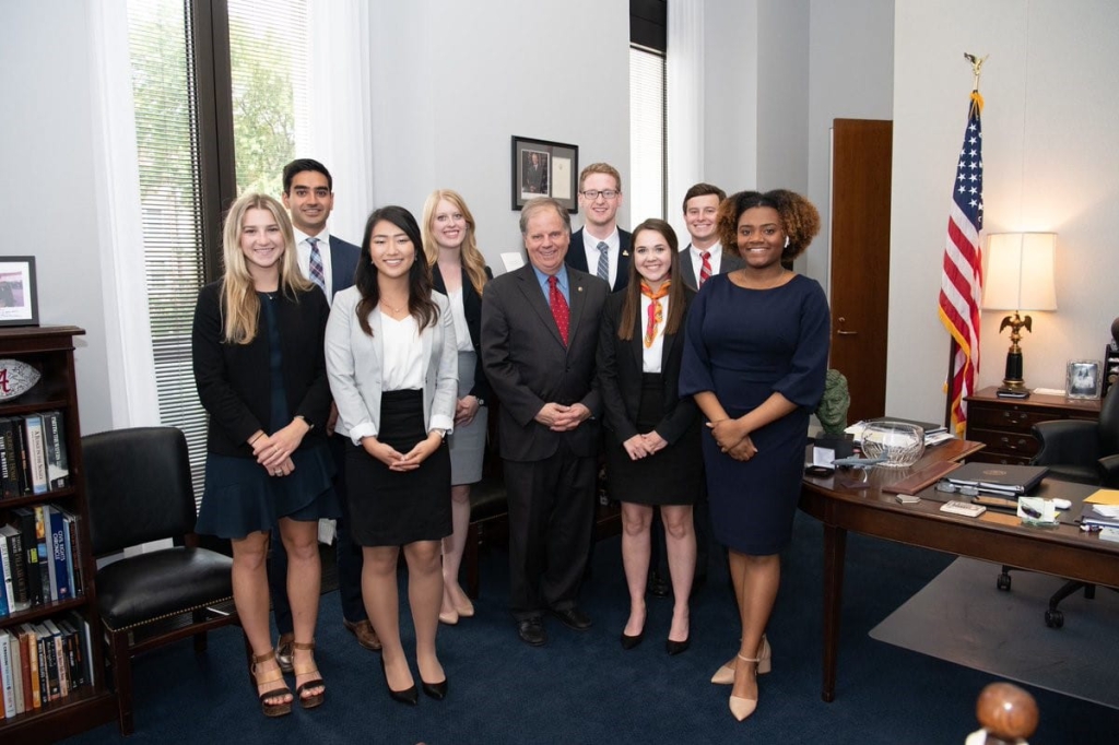 A group of interns poses with Senator Doug Jones