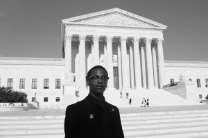 A young man stands in front of the Supreme Court